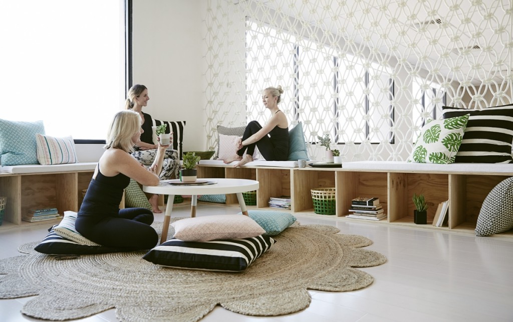 Women chatting in seated area within yoga studio