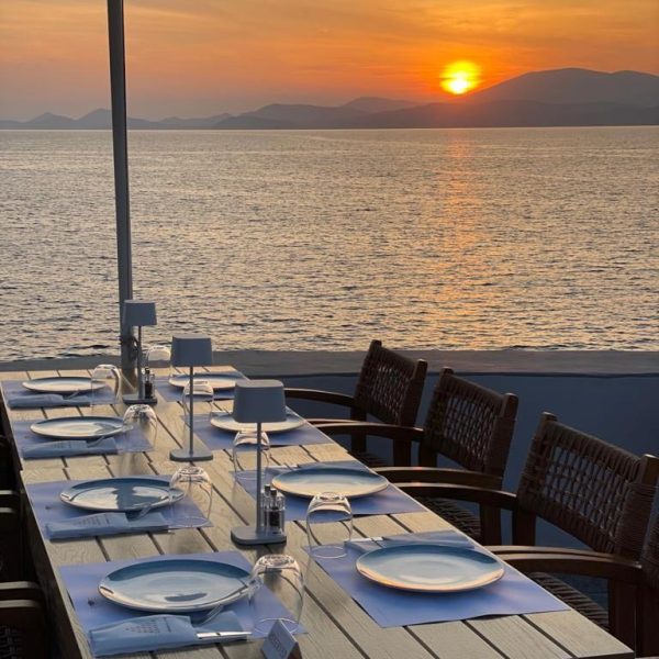 Table setting at Greek retreat with ocean and sunset in the background